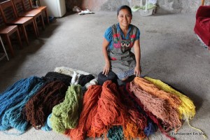 Señora Graciela, in her home, with the materials she uses to create these beautiful products.